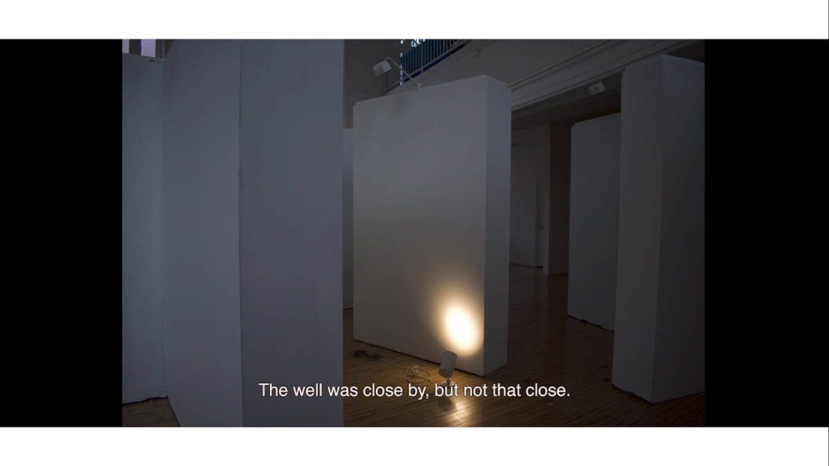 Video still, empty gallery wall with spotlight