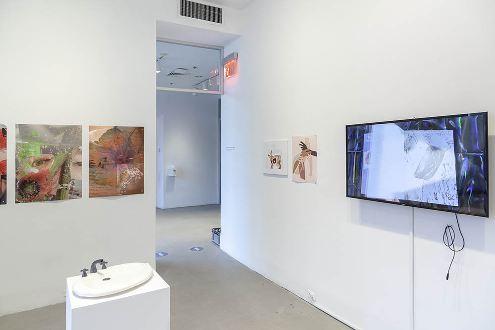 Exhibition view, with works on paper and video screen handing on the wall, with a sculpture on a pedestal in the foreground.